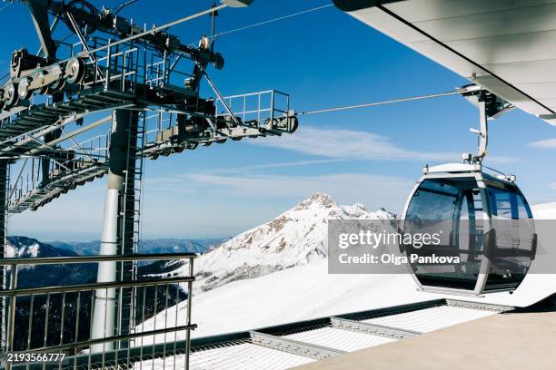 gondola lift transporting skiers up snowy mountain slopes on a bright sunny winter day - sochi snow stock pictures, royalty-free photos & images
