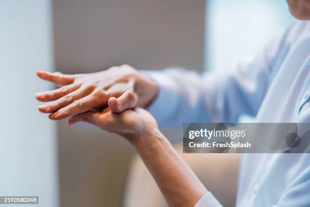 primer plano de las manos siendo masajeadas en un entorno relajante - reiki fotografías e imágenes de stock