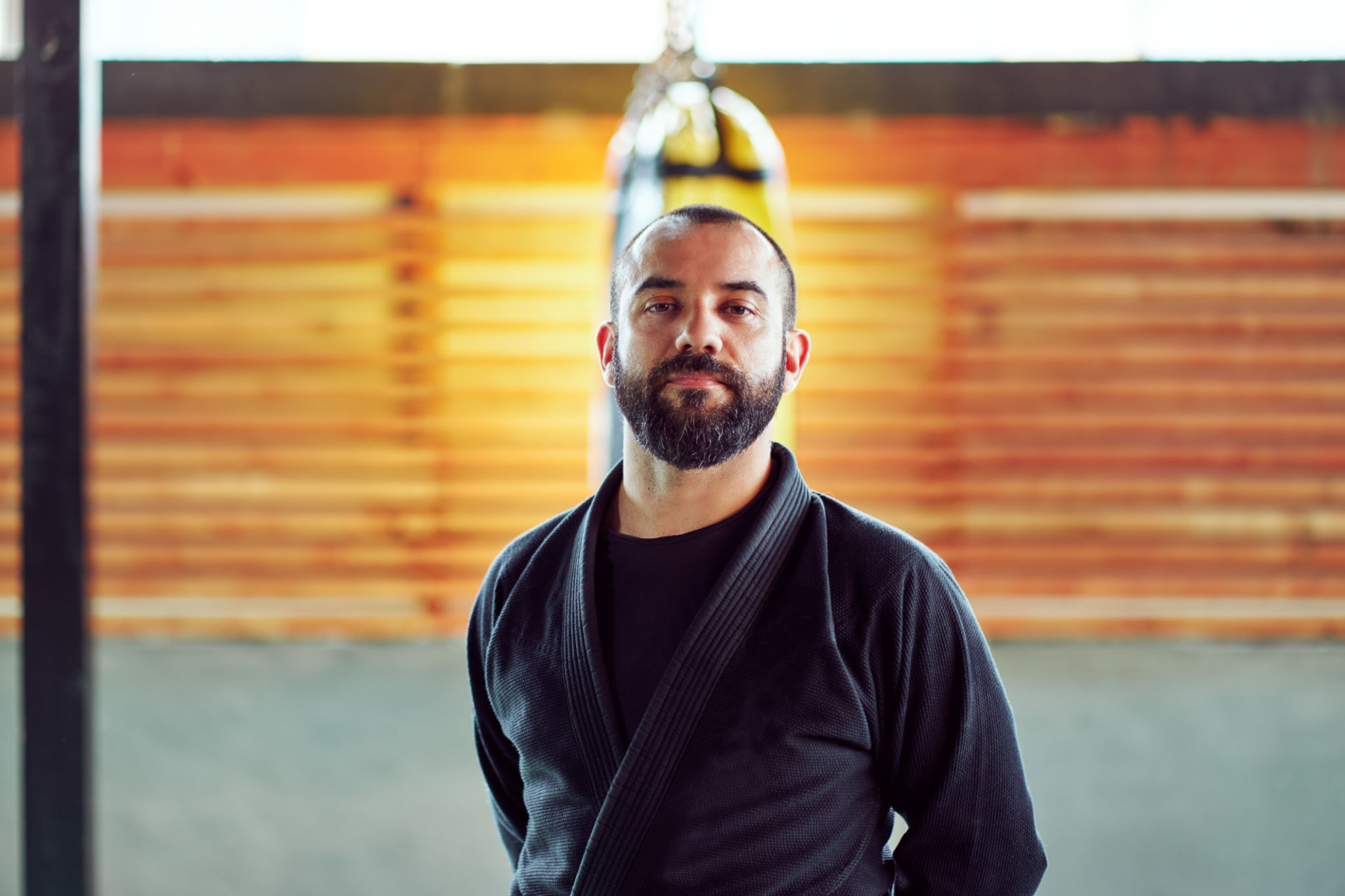 Portrait of a martial arts master posing in his dojo, wearing a black kimono and brown belt Portrait of a martial arts master posing in his dojo, wearing a black kimono and brown belt