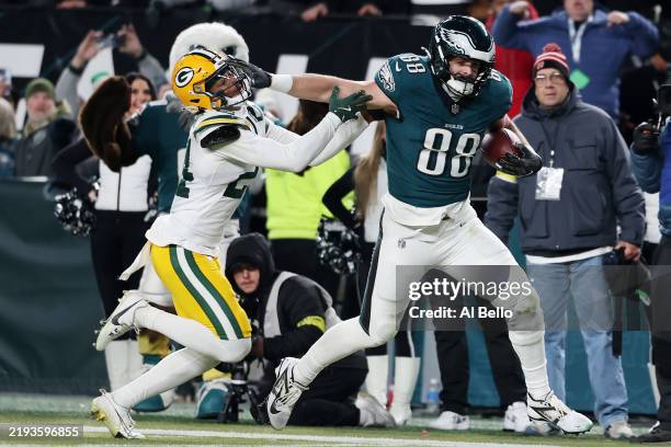 Dallas Goedert of the Philadelphia Eagles stiff arms Carrington Valentine of the Green Bay Packers before scoring a third quarter touchdown during...
