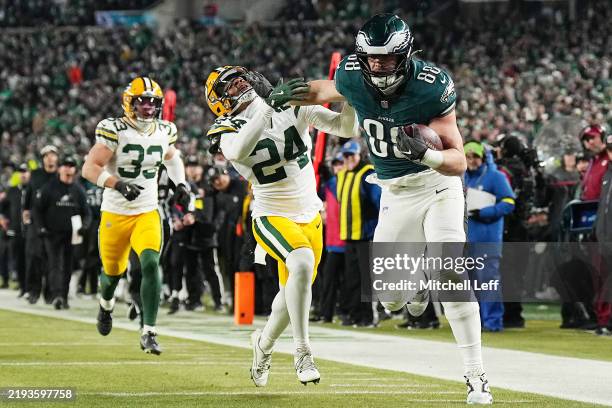Dallas Goedert of the Philadelphia Eagles stiff arms Carrington Valentine of the Green Bay Packers before running for a third quarter touchdown...