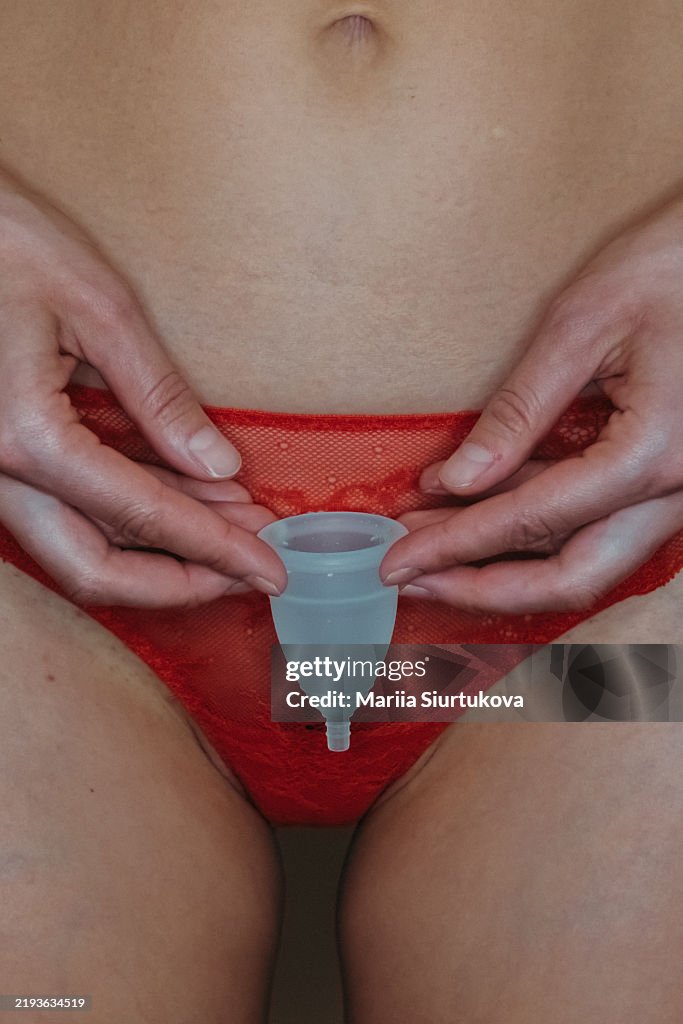 Menstrual health awareness with menstrual cup and red lace underwear.