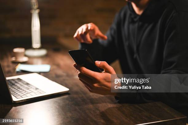 verletzen von daten, nahaufnahme der hände mit mobiltelefon. - wirtschaftskriminalität stock-fotos und bilder