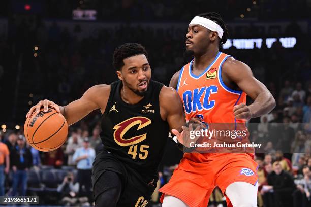 Donovan Mitchell of the Cleveland Cavaliers looks to drive past Luguentz Dort of the Oklahoma City Thunder during the first half at Paycom Center on...
