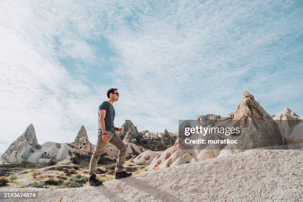 randonnée sur des formations rocheuses uniques en cappadoce - cheminée de fée photos et images de collection