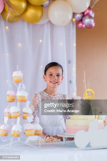 portrait of a beautiful girl making her first communion looking at the camera proud with her party decoration - sacrament stock pictures, royalty-free photos & images