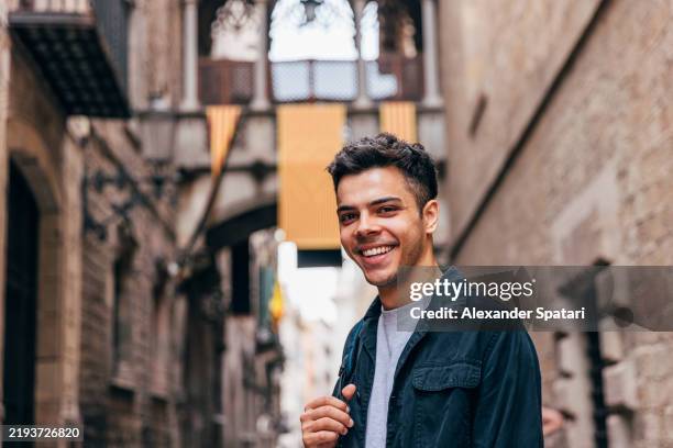 portrait of a happy smiling young man on the streets of barcelona gothic quarter, catalonia, spain - spanish man portrait stock pictures, royalty-free photos & images