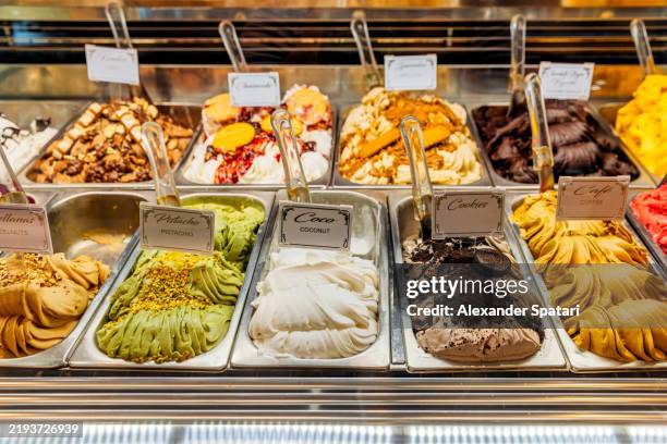 variety of gelato ice cream flavours in the fridge at the ice cream shop - gelato italiano foto e immagini stock