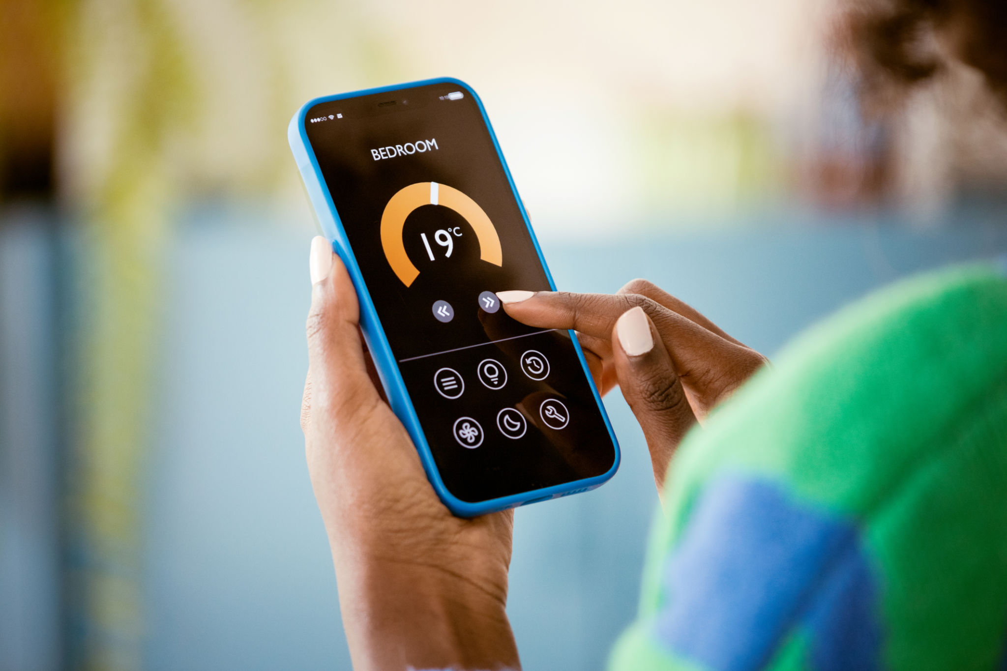 Woman using mobile phone to control termostat at home Woman using mobile phone to control termostat at home