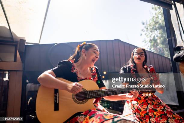 female musicians playing the guitar and tambourine at a folkloric cueca event in chile - latin music stock pictures, royalty-free photos & images
