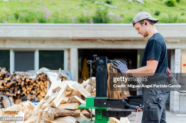 lumberjack cutting logs on a hydraulic machine - waldarbeiter stock-fotos und bilder