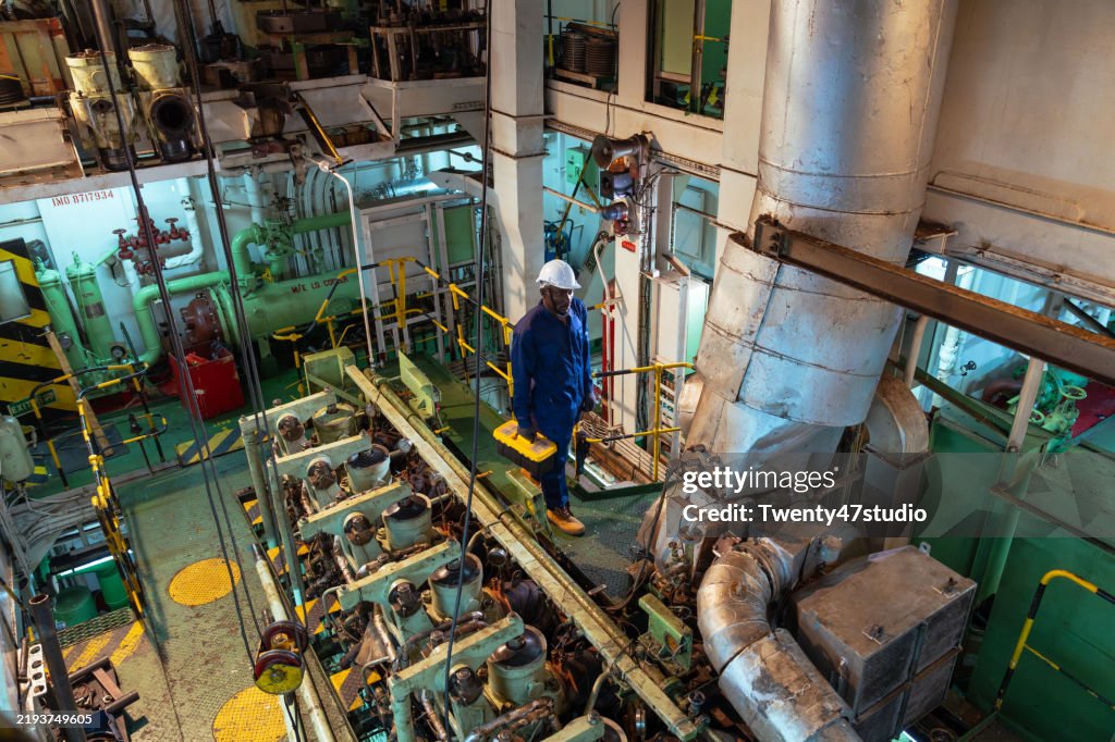 Portrait of a ship worker is walking in the ship's engine room