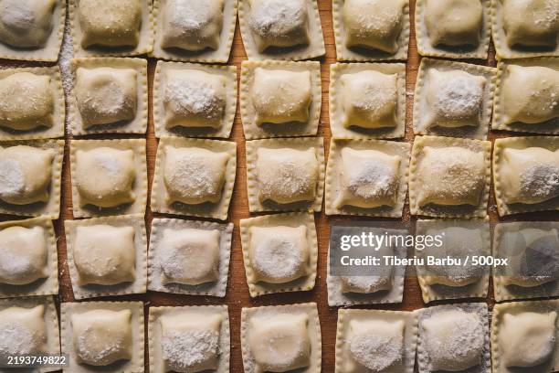 raw traditional italian ravioli with flour,basil,egg,and salt on a wooden board - ravioli fotografías e imágenes de stock