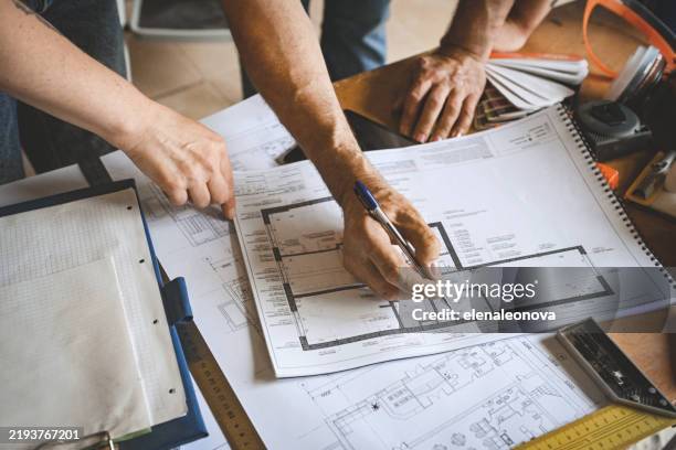 family makes an agreement with a worker doing renovations in the apartment - schematics stock pictures, royalty-free photos & images