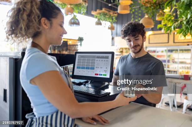 man making a contactless payment at a coffee shop - point of sale stock pictures, royalty-free photos & images