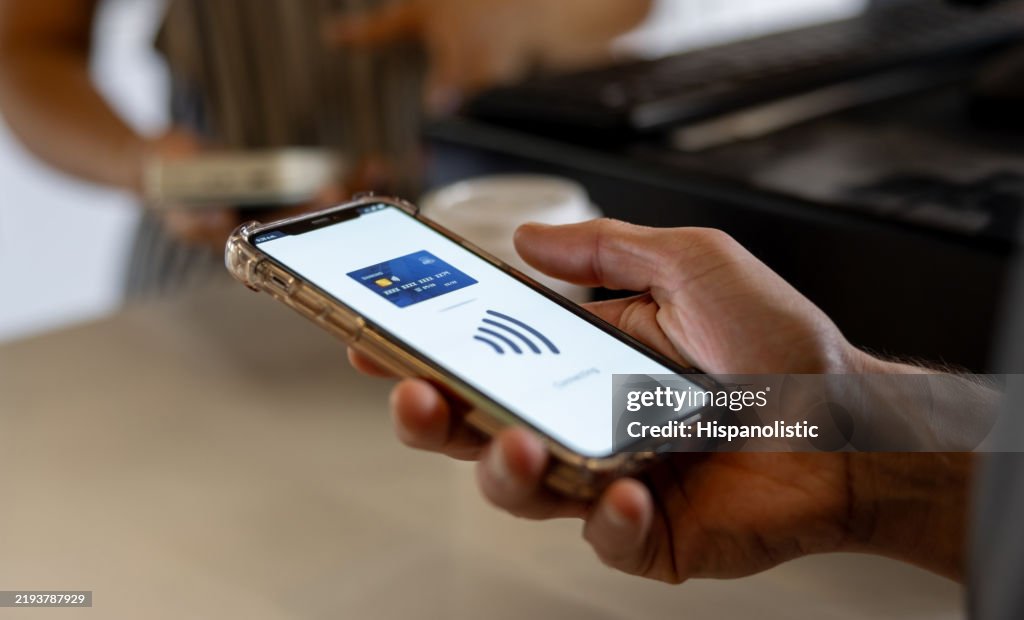 Close-up on a client making a mobile payment at a cafe