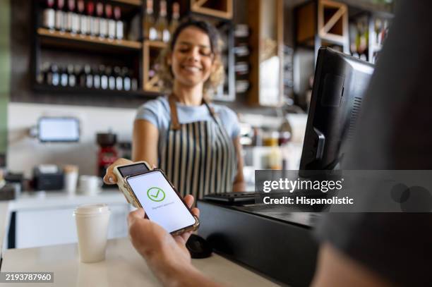 customer making a mobile payment at a coffee shop - tap to pay stock pictures, royalty-free photos & images