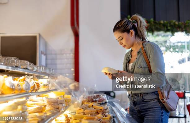 mujer comprando queso en una charcutería - queso en forma redonda fotografías e imágenes de stock