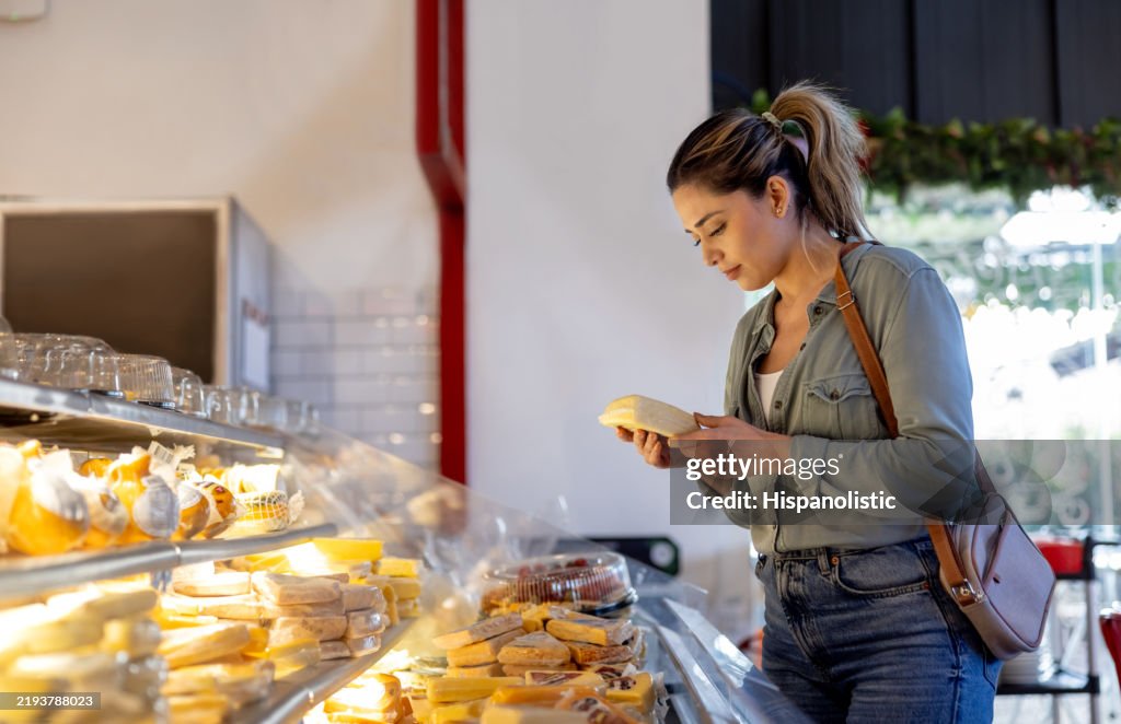 Woman buying cheese at a delicatessen