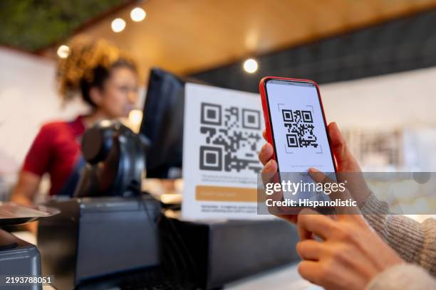 close-up on a woman making a mobile payment scanning a qr code - código-de-barras imagens e fotografias de stock