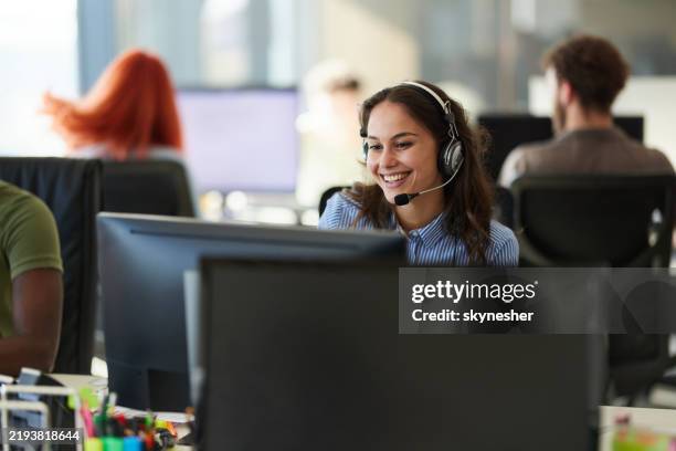 représentante du service clientèle féminine heureuse travaillant sur pc au bureau. - maintenance informatique photos et images de collection