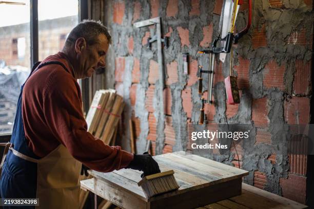 a carpenter working in his workshop. - cleaning sawdust stock pictures, royalty-free photos & images