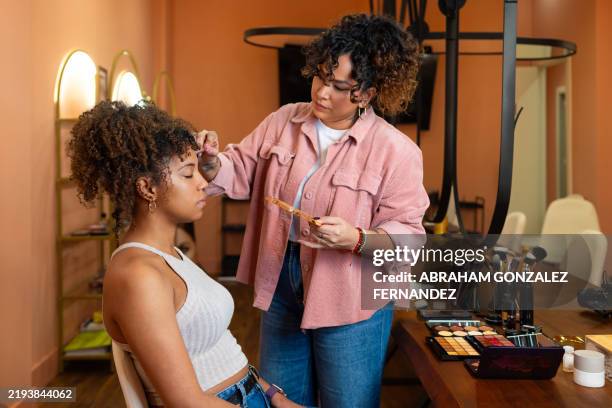 professional makeup artist perfecting client's complexion during beauty salon makeover - makeup artist stock pictures, royalty-free photos & images