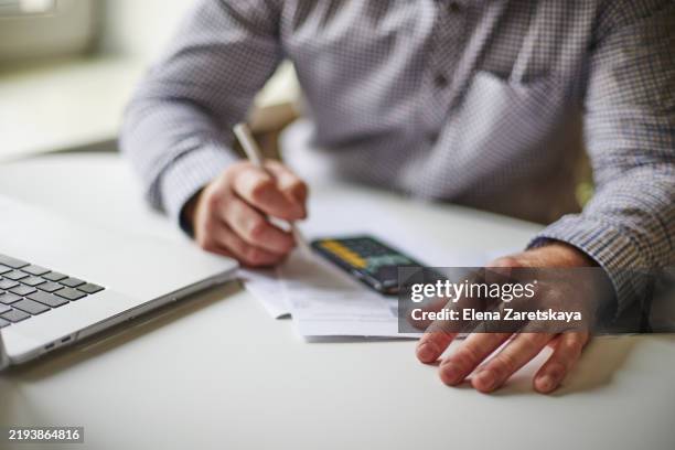 business professional writing notes while using a smartphone and laptop - arranging stock pictures, royalty-free photos & images