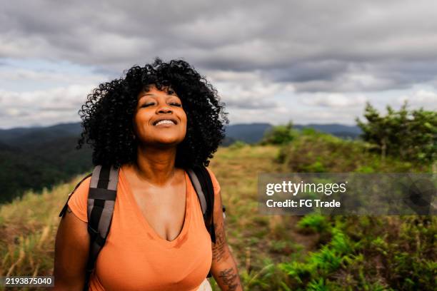 mid adult woman contemplating during hiking on mountain peak - self love stock pictures, royalty-free photos & images