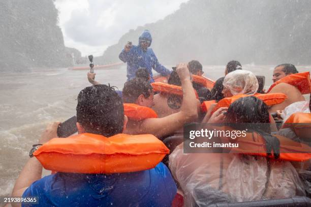 cataratas del iguazú turistas en una embarcación de excursión en argentina - cataratas del iguazú fotografías e imágenes de stock