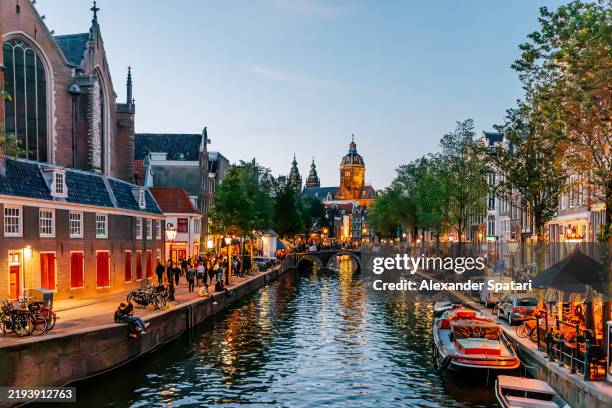 red light district and basilica of saint nicholas illuminated at dusk, amsterdam, netherlands - basilica of st nicholas amsterdam stock pictures, royalty-free photos & images