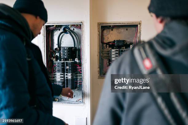 électriciens travaillant sur des panneaux électriques - tableau de commande photos et images de collection
