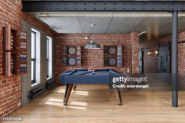 salle de jeux de style industriel avec table de billard, jeux de fléchettes, suspension et mur de briques - billard photos et images de collection