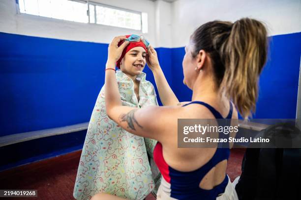 madre ayudando a su hijo a poner gafas de natación en una habitación - young boys changing in locker room fotografías e imágenes de stock