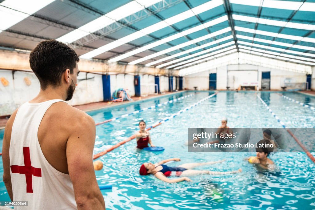 Lifeguard talking to swimmers on a swimming pool
