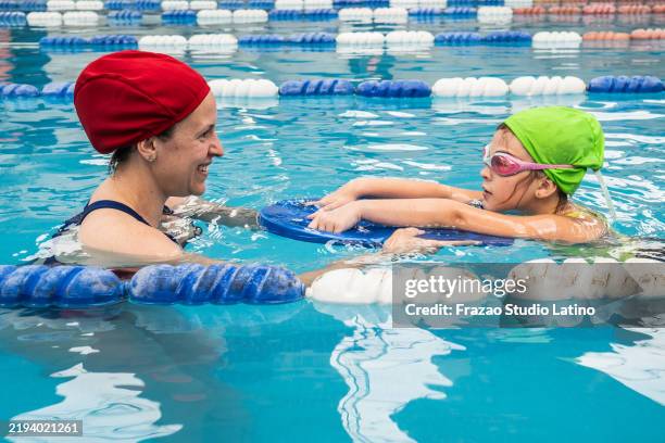 profesor enseñando a un estudiante en una piscina - swimming teacher fotografías e imágenes de stock