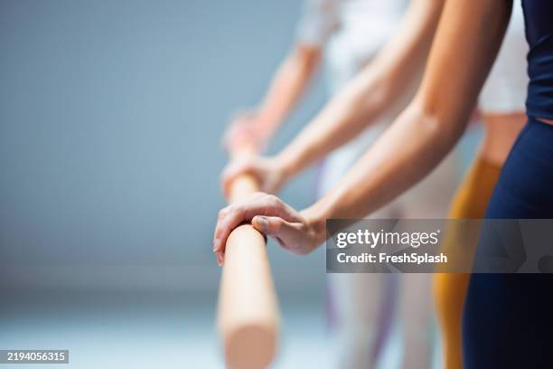 konzentrierte individuen, die ballett in einer bar in einer studioumgebung üben - ballettstange stock-fotos und bilder