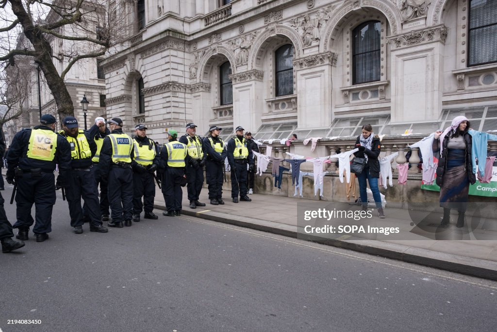 Next to a group of police, a chain of baby clothes and...