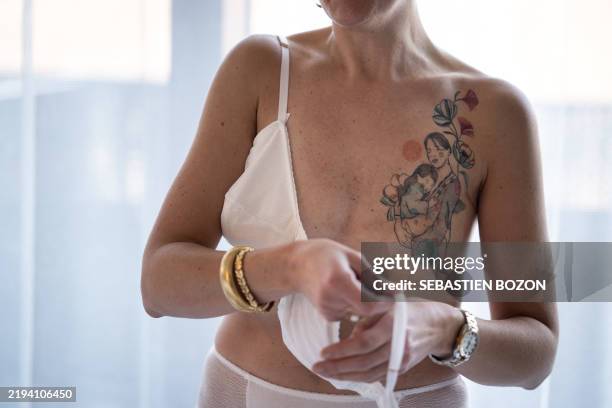 Graphic content / Model Marie-Eve, who has had her breast removed, puts on a bra with a prothesis during a photoshoot of French designer Fanny...