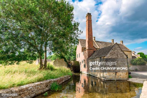 old water mill reflecting on the eye river in lower slaughter, cotswolds, england - mill stock pictures, royalty-free photos & images