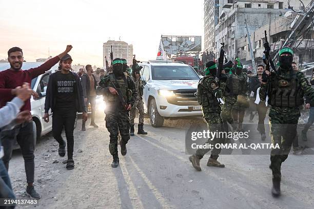 Fighters of the Ezzedine al-Qassam Brigades, Hamas's armed wing, escort vehicles of the International Committee of the Red Cross in Saraya Square in...