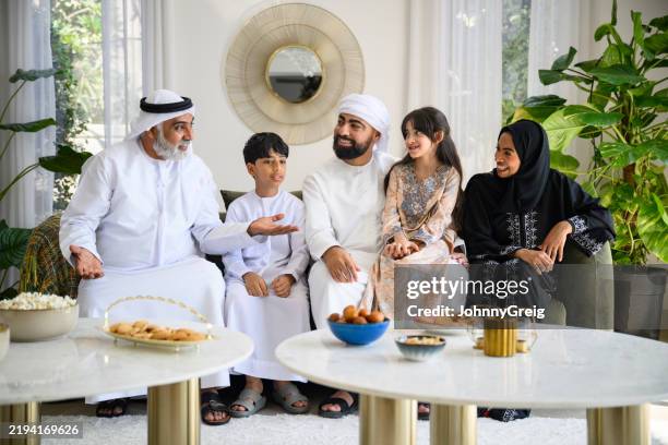 offenes porträt von drei generationen familien aus dem nahen osten, die miteinander reden und es genießen, eid-ul-fitr zu feiern - vereinigte arabische emirate stock-fotos und bilder