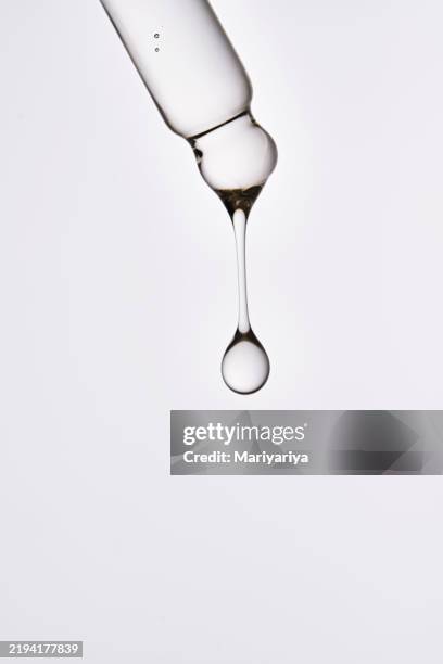 close-up of a pipette with a flowing cosmetic product. serum texture. - pipette stock-fotos und bilder