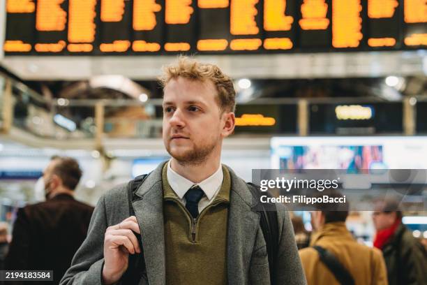 businessman looking at schedule board in train station - commuter train stock pictures, royalty-free photos & images