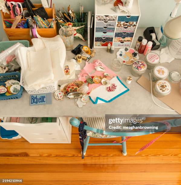 overhead view of assorted fabrics, tools and craft objects on a table in a studio - cluttered desktop stock pictures, royalty-free photos & images