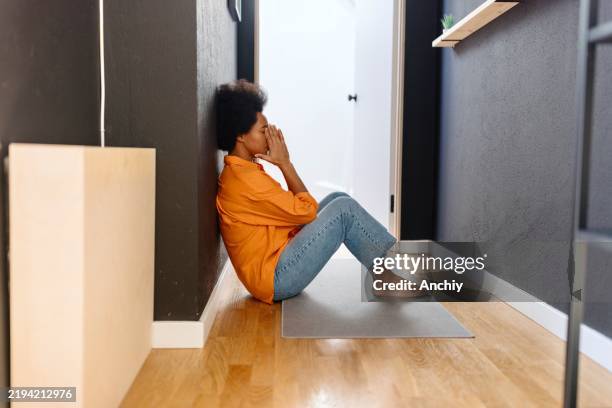 vista lateral de una mujer estresada sentada en el suelo - hipoglicemia fotografías e imágenes de stock