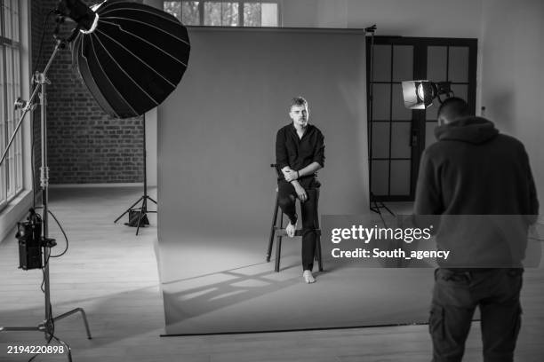 foto in bianco e nero di un uomo in studio fotografico. - dietro le quinte concetto foto e immagini stock