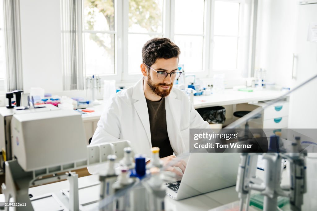 Focused Male Scientist Using a Laptop in a Research Laboratory