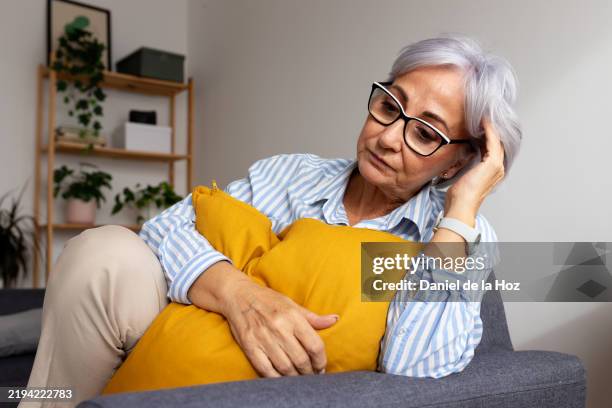 senior woman feeling sad and lonely at home - witwe stock-fotos und bilder