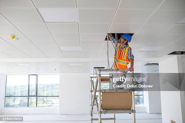 construction electrical engineer on a construction site. - fitting stockfoto's en -beelden